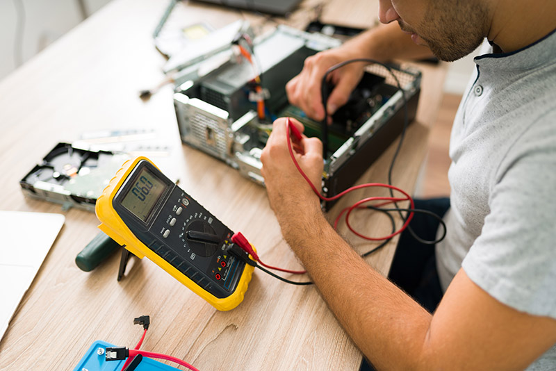 Professional engineer connecting a multimeter to a pc Elektronische Überprüfungen